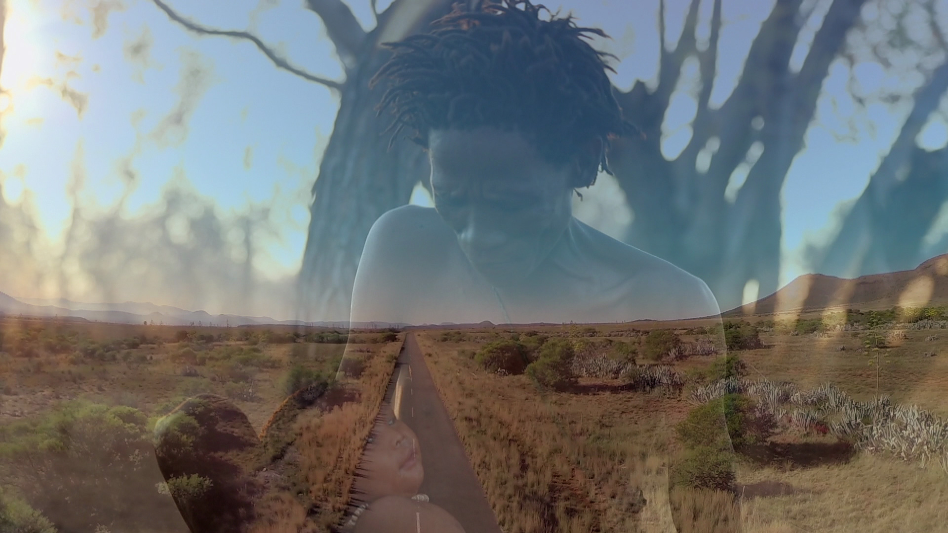 A double exposure image features a person with a thoughtful expression overlaid on a landscape of a road stretching into the distance surrounded by bushes and low vegetation. The merging images create a serene and contemplative feel.